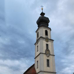 Kirche in Binzwangen mit Glockenturm beim Mittagsläuten